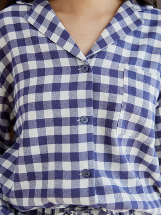 Close-up of checkered long sleeve sleep shirt with classic button-down design and chest pocket in blue and white pattern.