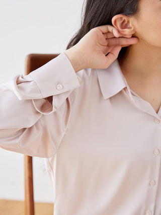 Woman wearing a luxurious satin sleepwear blouse with long sleeves and a pointed collar, showcasing elegant fabric sheen and relaxed fit.