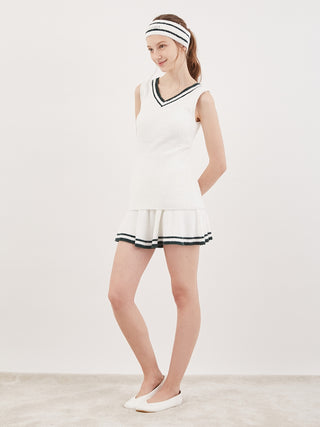 Woman wearing a white tennis outfit with a Smoothie Logo Jacquard Hairband, inspired by uniform style and chic designs.
