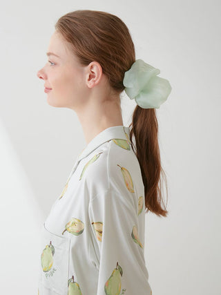 Woman wearing a sheer green scrunchie from Gelato Pique, featuring delicate embroidery, styled elegantly in brown hair.