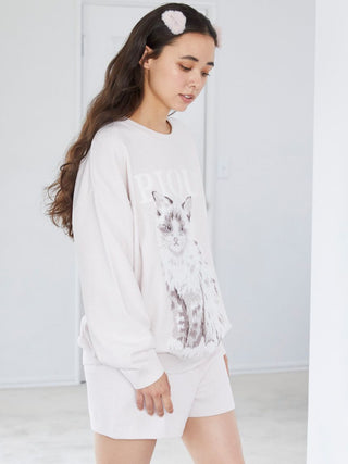 Woman wearing a cozy sweater with a cat design, paired with matching shorts and an eco-friendly fur hair clip.