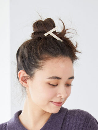 Woman wearing a stylish bun with a Gelato Pique metal hair clip featuring black enamel and gold-tone edges.