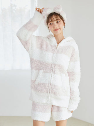 Woman wearing Gelato 2 Border Headband and matching fluffy loungewear in pastel pink and creamy white stripes, standing indoors.