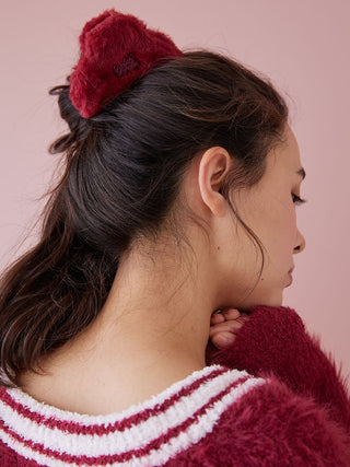 Woman wearing a Gelato Pique faux fur hair clip, showcasing elegant holiday style with warm and sophisticated design.