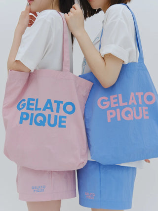 Pastel tote bags by Gelato Pique in pink and blue, featuring bold branding, styled with casual outfits. Ideal for trendy, minimalist fashion.