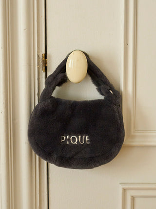 Black faux fur mini handbag from Gelato Pique hanging on a door handle.
