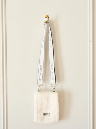 Alt Tag: Faux Fur Mini Sling Bag by Gelato Pique hanging on wall, featuring soft eco-friendly material and adjustable branded strap.