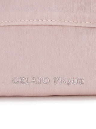 Close-up of blush pink fabric with "Gelato Pique" embossed in silver lettering, showcasing texture and detail.
