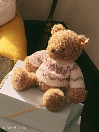 Steiff Teddy Bear Jimmy by Gelato Pique sitting on a gift box, showcasing its fluffy texture and cozy design.