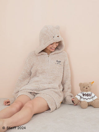 Person in cozy bear-themed attire next to Steiff Teddy Bear Jimmy from Gelato Pique collaboration.