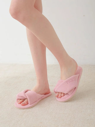 Luxurious pink pile cozy indoor slippers on woman's feet, featuring wide overlapped strap for a snug fit. Perfect for home comfort.