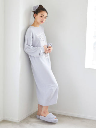 Person wearing cozy outfit with Gelato Pique Eco Fur Fuzzy Slippers in light-filled room, showcasing comfort and style.