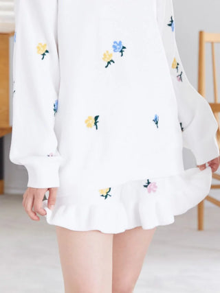Person wearing Air Moco flower lounge shorts and matching top with floral embroidery.