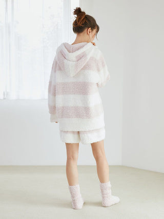 Woman wearing Gelato 2 Border Lounge Shorts with a plush hoodie, showcasing a pastel two-tone border pattern, standing in a room.