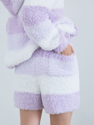 Woman wearing fluffy Gelato 3 Border Lounge Shorts in pastel pink and white, showcasing cozy and stylish lounge wear.