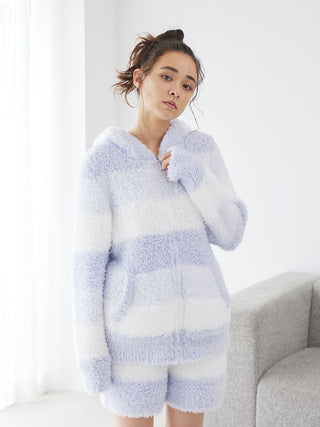 Woman wearing Gelato 3 Border Lounge Shorts in fluffy fabric with soft blue and white stripes, posing indoors on a sunny day.