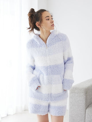 Woman wearing fluffy blue and white striped lounge outfit in a bright room.