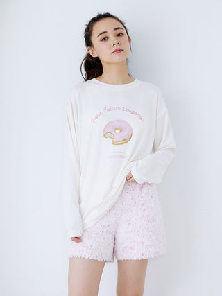 Woman wearing fuzzy lounge shorts with drawstring and white sweatshirt featuring donut graphic, showcasing cozy chic fashion.