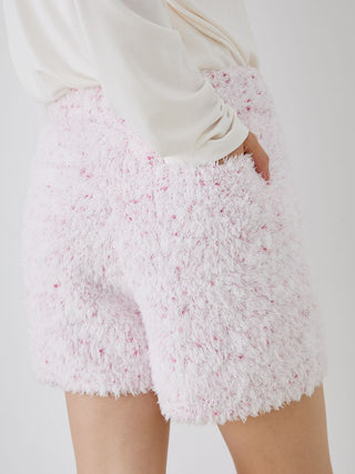 Woman wearing pink fuzzy lounge shorts with drawstring, textured cozy fabric, and playful speckled design from Gelato Pique.