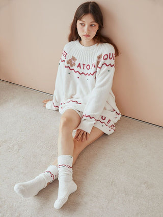 Woman wearing Nordic Lounge Shorts and sweater with Nordic-inspired design sitting on carpeted floor.