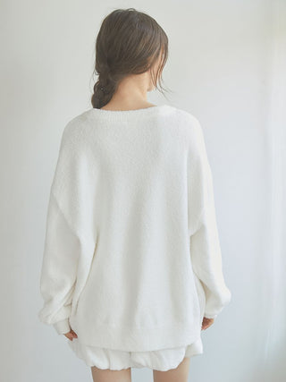 Woman wearing cozy white jacquard lounge shorts and sweater set, viewed from the back for relaxed loungewear style.