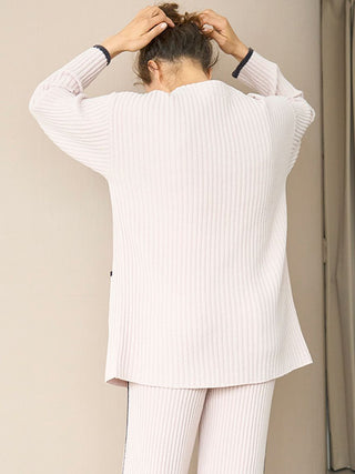 Back view of model wearing white ribbed knit cardigan and matching pants, showcasing the texture and relaxed fit of the Air Moco collection.