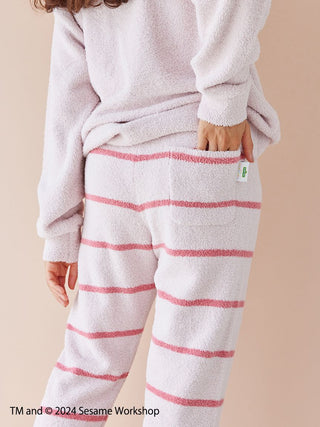 Child wearing Sesame Street motif jacquard pullover and striped long pants set made from Baby Moco fabric, back view.