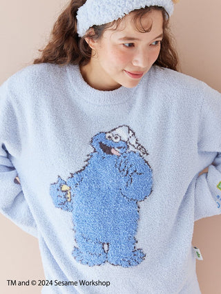 Woman wearing a blue Sesame Street motif jacquard pullover featuring Cookie Monster, made from soft Baby Moco fabric.
