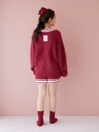 Back view of woman wearing a red feather button up cardigan with contrasting ribbed trim, cozy for winter nights and festive gatherings.