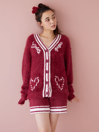 Woman wearing a plush feather button-up cardigan in deep red with ribbed trim, perfect for cozy warmth and festive style.