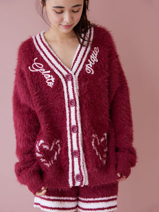 Woman wearing plush red feather button-up cardigan with festive heart pattern and contrasting ribbed trim.