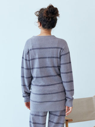 Back view of a woman wearing a Hot Smoothie Border Cardigan in striped pattern, showcasing the cozy design.