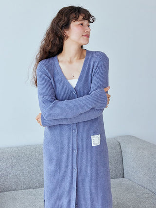 Woman wearing blue Hot Smoothie Ribbed Long Cardigan by Gelato Pique, showcasing soft ribbed texture and cozy style on a grey sofa.