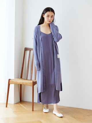 Woman wearing Hot Smoothie Ribbed Long Cardigan in purple with a matching dress, standing by a wooden chair, showcasing loungewear style.