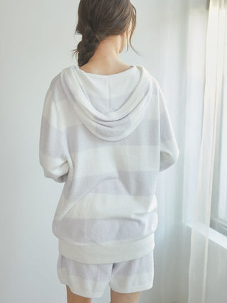 Woman wearing Smoothie 2-Border Zip-Up Hoodie from Gelato Pique USA, featuring soft fabric and stylish stripe design in a cozy setting.