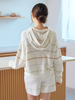 Woman wearing Smoothie Colorful Zip-Up Hoodie in cozy lounge setting, showcasing comfort and playful striped design by Gelato Pique USA.