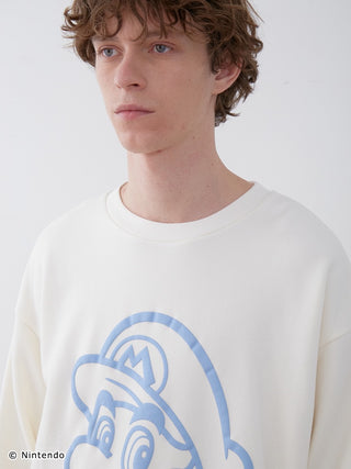 Model wearing SUPER MARIO™️ fleece pullover with Mario design, showcasing soft cotton fabric and puff print style.