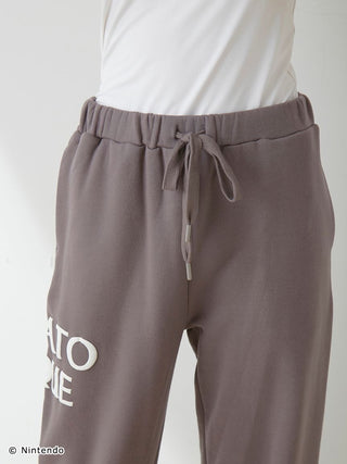 Close-up of SUPER MARIO™️ unisex fleece long pants with drawstring waist and elasticized hems, featuring Mario-themed puff print.