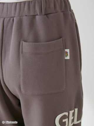 Back view of brown fleece pants from the SUPER MARIO™️ Unisex Set, featuring a pocket and logo on the side.