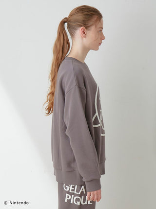 Side view of a model wearing a SUPER MARIO unisex fleece pullover and long pants set in grey with puff print design.
