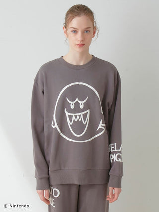 Model wearing Super Mario unisex fleece pullover and pants with Boo print, featuring elasticized hems and soft cotton-lined fabric.