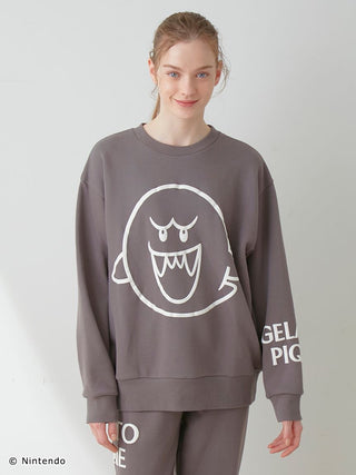 Person wearing Super Mario unisex fleece pullover with Boo print and matching pants, soft cotton-lined fabric, elasticized hems.