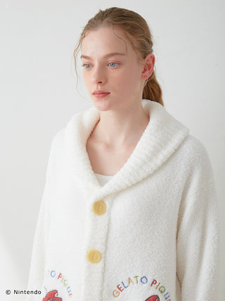 Model wearing white SUPER MARIO™️ unisex Baby Moco jacquard shawl cardigan with soft fluffy texture and yellow buttons.