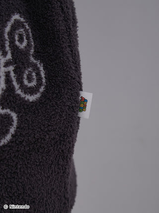 Close-up of Super Mario Baby Moco cardigan fabric showing tag and character pattern on soft, fluffy material.