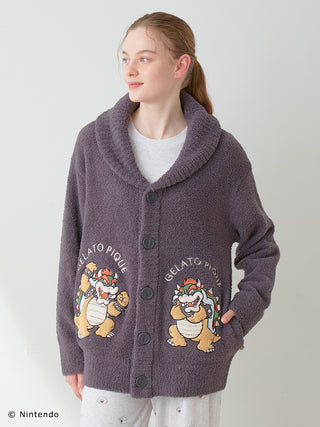 Model wearing Super Mario unisex Baby Moco shawl cardigan with Bowser design, showcasing soft and fluffy knitwear by Nintendo.