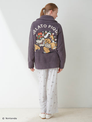 Person wearing Super Mario unisex Baby Moco jacquard shawl cardigan with character design on back, paired with light pants.