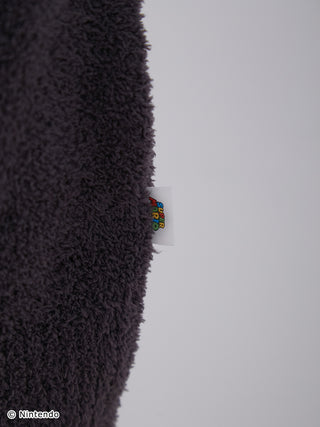 Close-up of Super Mario-themed Baby Moco jacquard cardigan fabric showcasing its soft, fluffy texture and logo tag.