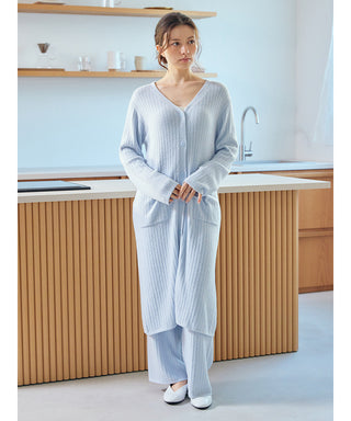 Woman wearing a Thermal Smoothie Long Cardigan in a modern kitchen setting, showcasing its ribbed texture and comfortable design.
