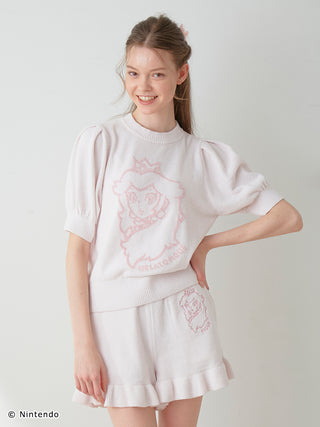 Model wearing Peach Collection pullover and shorts set with puff sleeves, ruffles, and character design, made from light, airy Moco fabric.