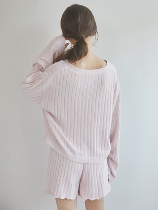 Woman modeling a pink 2025 ribbed cardigan and shorts set, showcasing cozy style and effortless elegance in loungewear.